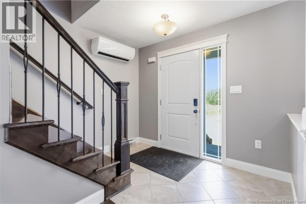 Side exterior view of a grey townhouse with a green lawn and paved street. - 65 Belle-foret, Dieppe