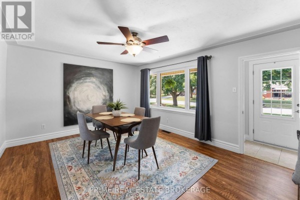 Dining room with a wooden table, grey chairs, patterned rug, and large window. - 65 David Street, London South