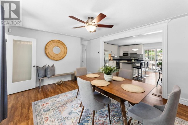 Dining area with a bench, mirror, door, and view into a modern kitchen. - 65 David Street, London South