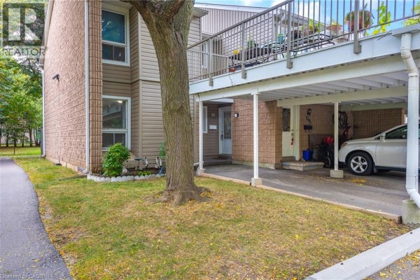 Side view of townhouse exterior with vinyl siding and brick accents. - 65 Glamis Road Unit# 74, Cambridge