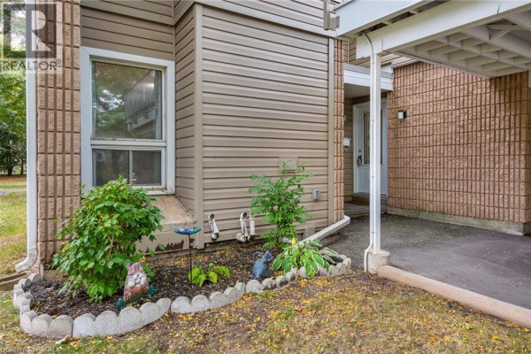 Ground level townhouse exterior with planter bed and decorative owls. - 65 Glamis Road Unit# 74, Cambridge