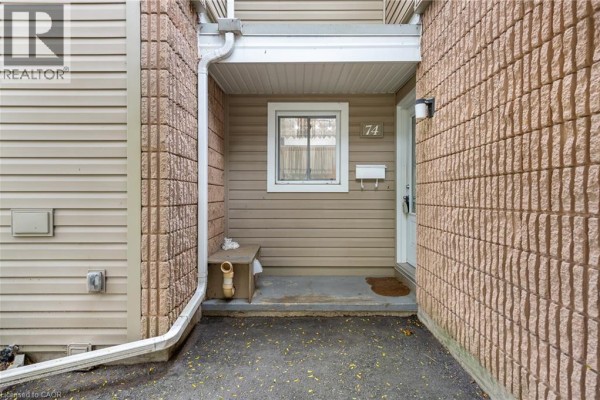Townhouse entrance with covered porch, window, and mailbox. - 65 Glamis Road Unit# 74, Cambridge