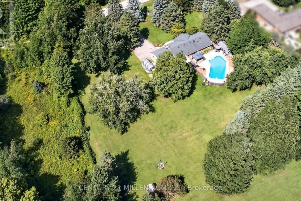 Aerial view of a large house with a pool and expansive green lawn. - 65 Maplewood Drive, Amaranth