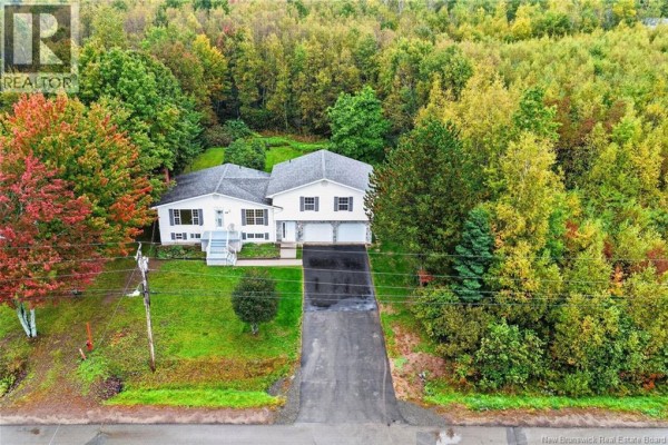 Aerial view of the white house surrounded by trees with colorful autumn foliage. - 65 Northwood Road, Moncton