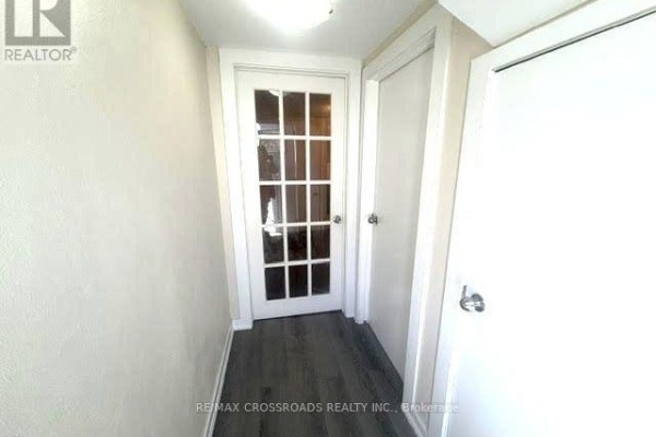A kitchen and dining area with light wood floors, white cabinets, and a table with four chairs. - 65 Romulus Drive, Toronto