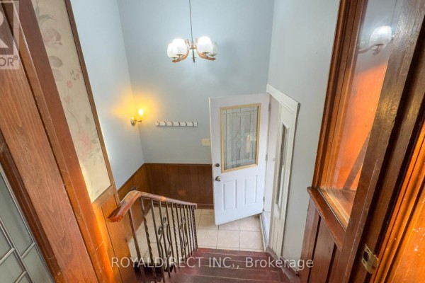 View of the interior staircase with red steps and wooden paneled walls. - 65 Sharbot Avenue, Toronto