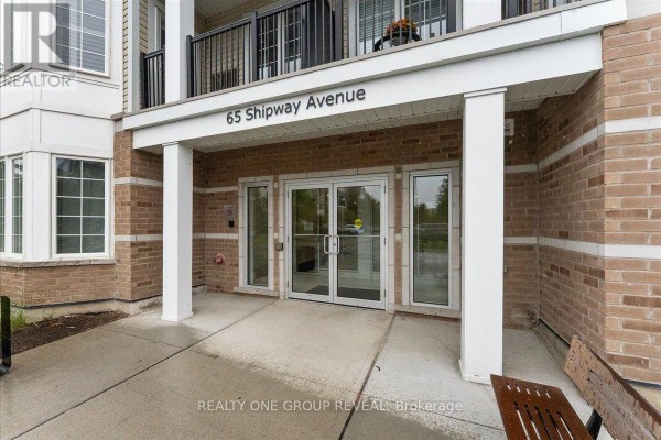 Close-up view of the building entrance at 65 Shipway Avenue with glass doors. - 111 - 65 Shipway Avenue, Clarington
