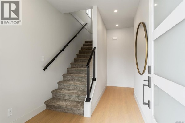 Interior view of a staircase with a black railing and carpeted steps leading upwards. - 650 Wisteria Ridge, Langford