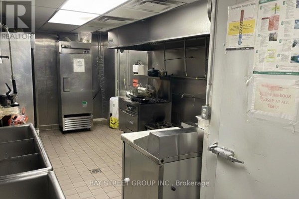 Commercial kitchen with stainless steel appliances and cooking equipment - 650 Yonge Street, Toronto