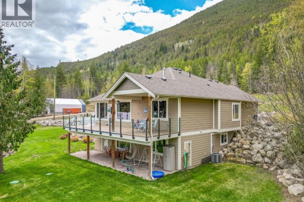Rear view of the house with a large deck and grassy yard. - 6500, 6450, 6425 1 Avenue Nw Lot# 1,2,3, Salmon Arm