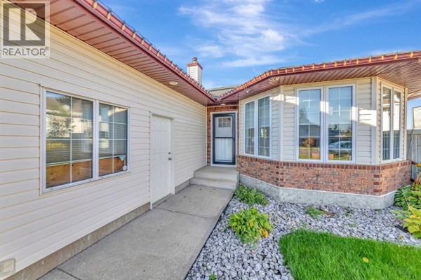 Front entrance of a house with a concrete walkway, brick accents, and bay windows. - 6501 39 Street, Lloydminster
