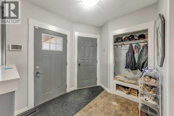 Interior entryway with two grey doors, a coat closet with storage, and tiled flooring. - 6501 39 Street, Lloydminster