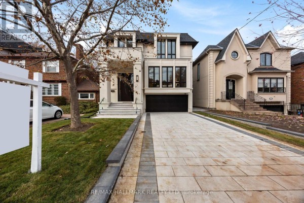 Entrance hall with a black modern door, glass panels, and grey tiled stairs. - 652 Bedford Park Avenue, Toronto