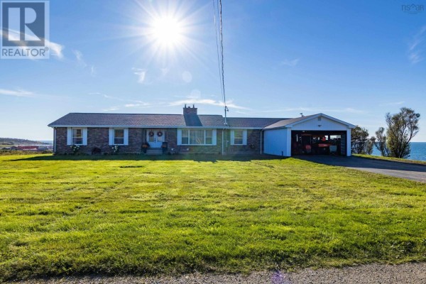 Exterior front view of a brick bungalow with attached carport and ocean view. - 653 Ross Durkee Road, Sandford