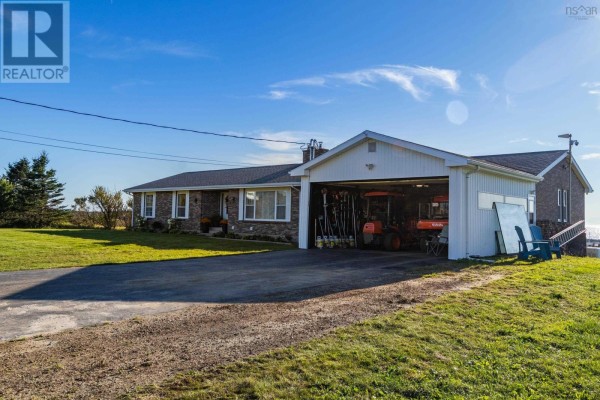 Side exterior view of brick bungalow with attached carport and garden furniture. - 653 Ross Durkee Road, Sandford