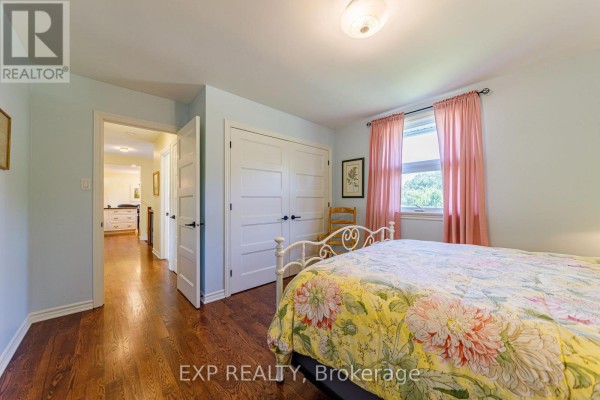 Bedroom with wrought iron bed, floral bedding, pink curtains, and closet - 6530 Bunker Road Ottawa