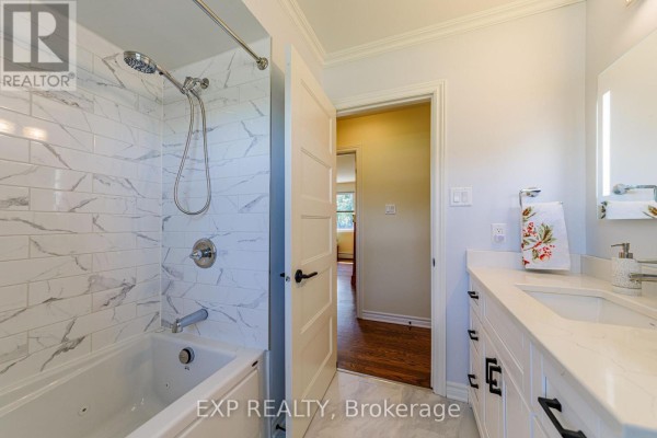 White bathtub with subway tile and dual-sink vanity - 6530 Bunker Road Ottawa