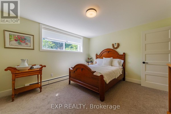 Wooden bed, wash stand, and artwork in a bedroom - 6530 Bunker Road Ottawa