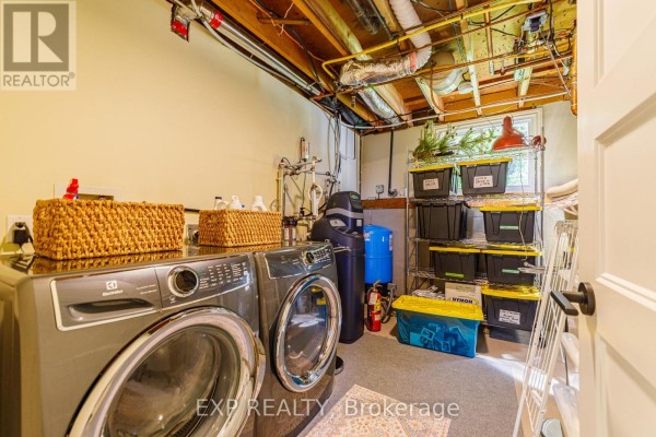 Electrolux washer & dryer, water heater, storage bins, and shelving in laundry room - 6530 Bunker Road Ottawa