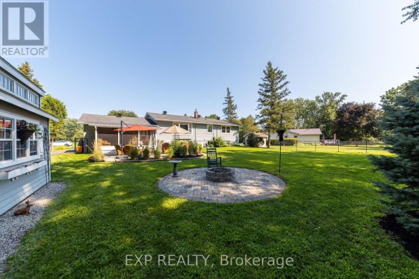 Circular paver patio with fire pit, screened porch and lawn - 6530 Bunker Road Ottawa