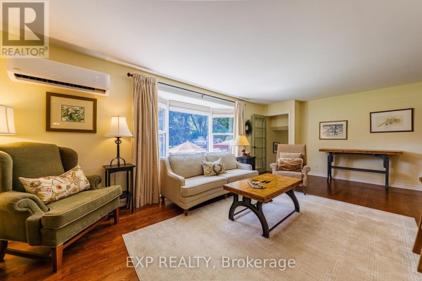 Living room with bay window, hardwood floors, and sofa - 6530 Bunker Road Ottawa