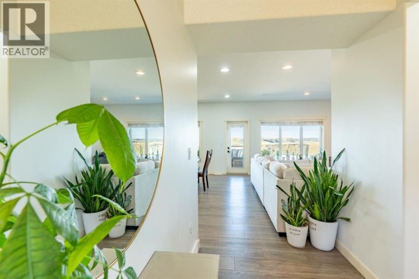 View from entryway into living room with large windows and white sofas. - 6531b Township Road 132, Rural Cypress County