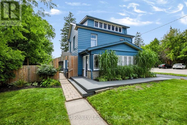 Front entrance of the blue commercial building with a gray deck and walkway. - 654 Duke Street, Cambridge