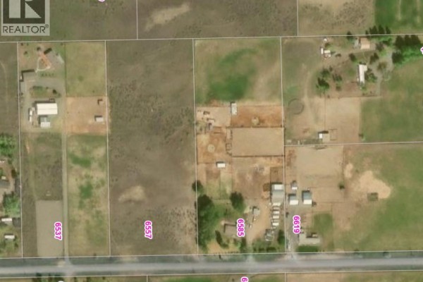 Aerial view of multiple rectangular land parcels divided by fences, some with buildings and structures. - 6557 Thompson River Drive W, Kamloops
