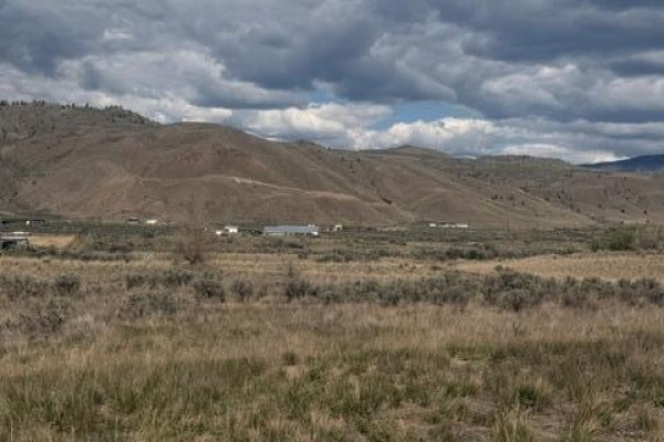 Aerial view shows Thompson River Drive W, bordered by the Thompson River and numerous properties. - 6557 Thompson River Drive W, Kamloops