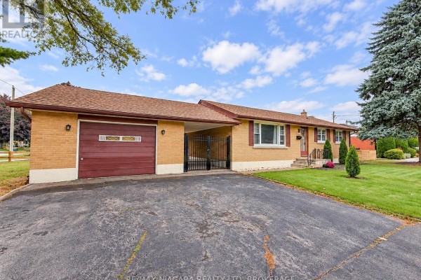 Front view of a beige brick bungalow with red shutters and manicured lawn. - 6558 O'neil Street, Niagara Falls