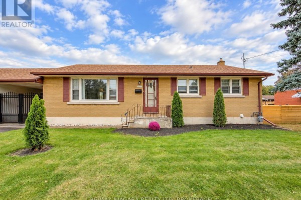 Front exterior of a single-story brick house with a driveway and lawn. - 6558 O'neil Street, Niagara Falls