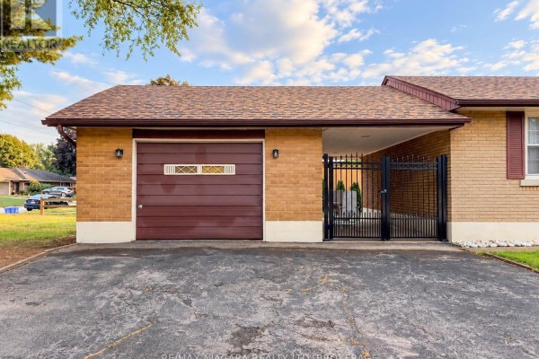 Close-up of the garage door, carport entrance, and brick exterior. - 6558 O'neil Street, Niagara Falls
