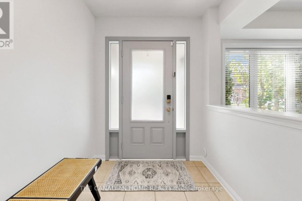 Interior entryway with a light gray door, frosted glass panels, and tiled floor. - 657 Cargill Path, Milton