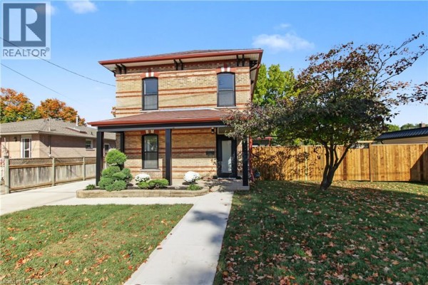 Backyard with a lawn, wooden shed, and raised garden beds with soil. - 657 Frances Street, Woodstock