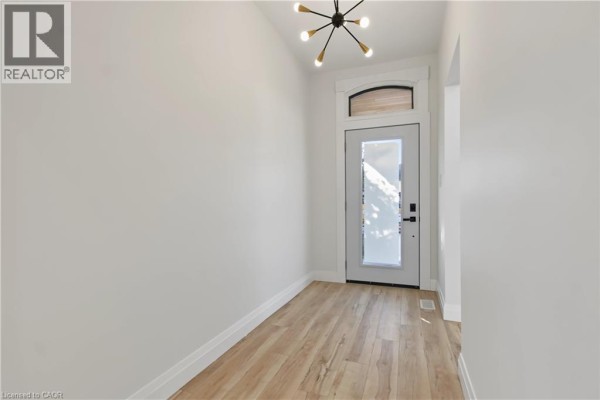 Backyard with a fenced garden, raised beds, wooden shed, and a two-story house. - 657 Frances Street, Woodstock