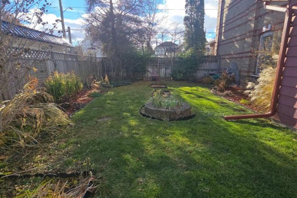 Backyard with lawn, trees, and raised garden bed - 657 Frances Street Woodstock