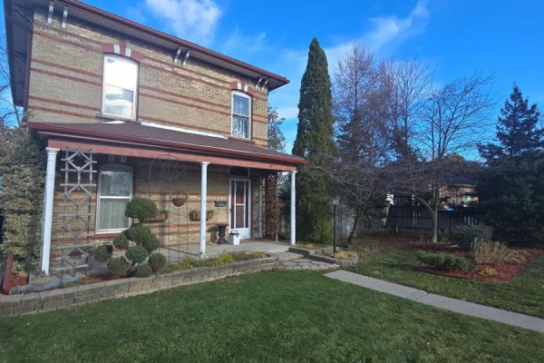 Brick house with porch and green lawn - 657 Frances Street Woodstock