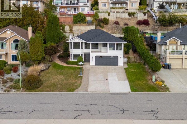 Aerial view of the house on a hill with a driveway and neighboring properties. - 657 Royal View Drive, Kelowna