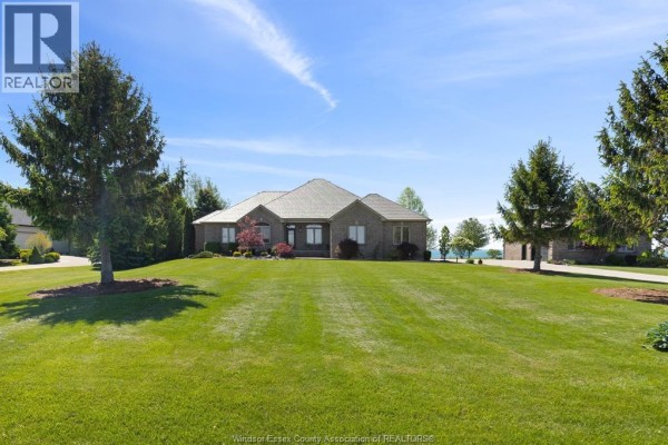 Three-car garage with concrete floor, lawnmower, bicycles, and storage shelves. - 6576 Talbot Trail, Merlin