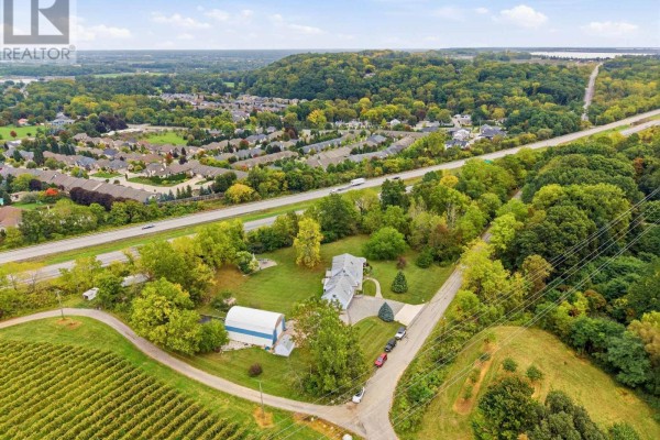 Aerial view of a property with a house, barn, and a highway nearby. - 6585 Steele Street, Niagara On The Lake