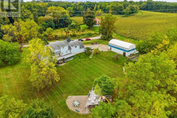 Rear aerial view of the house, backyard patio, barn, and vineyard. - 6585 Steele Street, Niagara On The Lake
