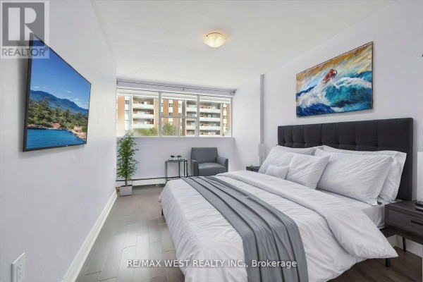 Cozy bedroom with a king bed, wall-mounted TV, and natural light from windows - 66 - 1624 Bloor Street E, Mississauga