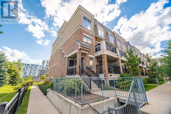 Exterior shot of a brick townhouse complex under a cloudy sky. - 66 - 2441 Greenwich Drive, Oakville