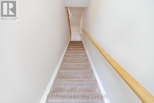 Carpeted staircase with beige walls and a wooden handrail leading upwards. - 66 - 60 Winston Park Boulevard, Toronto