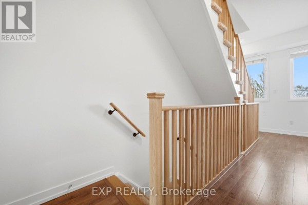 Wooden staircase railing with carpeted stairs and hardwood flooring on upper level. - 66 - 60 Winston Park Boulevard, Toronto