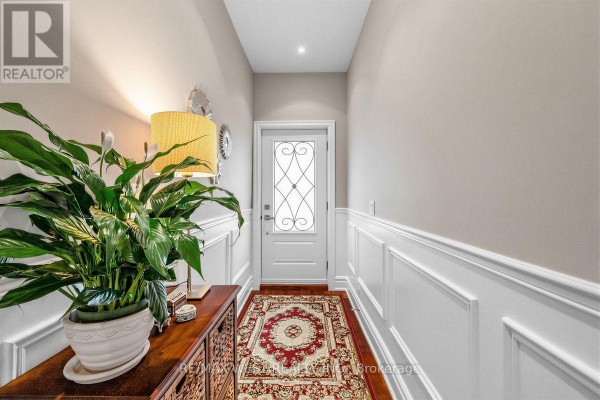 Interior hallway with white wainscoting, a red rug, and a console table. - 66 Bristol Avenue, Toronto