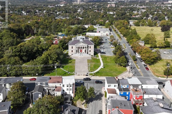 Aerial view of St. John's, Newfoundland, showing a historic building with columns, tree-lined streets, and residential homes. - 66 Colonial Street, St  John S