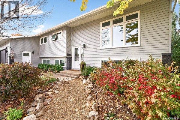 Gray vinyl siding on the front of the house with multiple windows and front entrance. - 66 Edelweiss Crescent, Moose Jaw