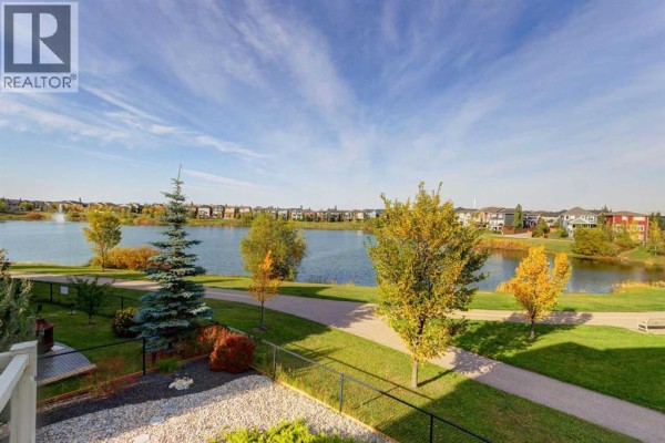 View of a suburban lake with surrounding houses and autumn foliage. - 66 Legacy Green Se, Calgary