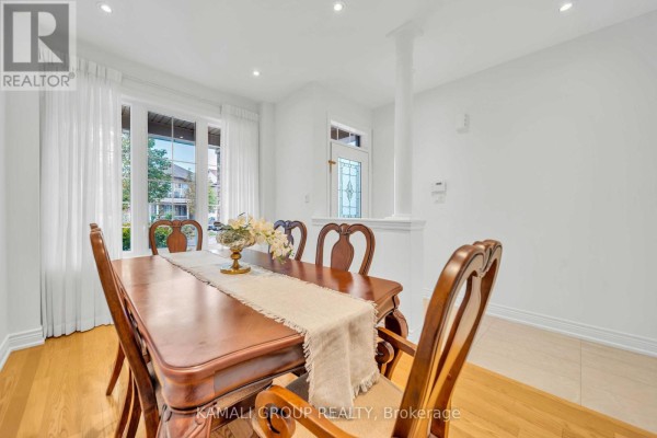 Dining room with a wooden table set for six, light wood floors, and large white curtains. - 66 Longwood Avenue, Richmond Hill
